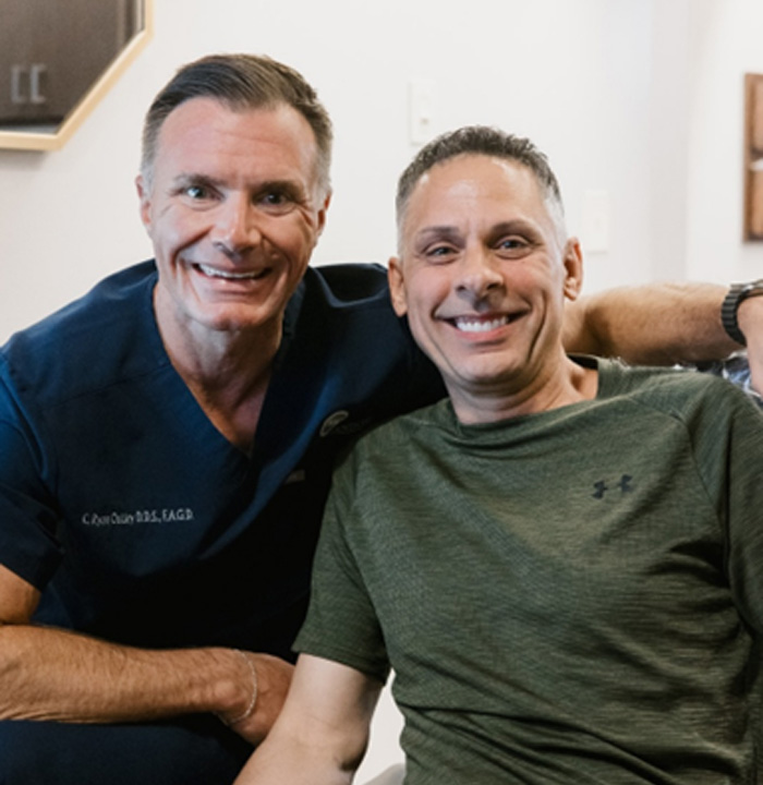 Dentist smiling with patient after discussing cost of cosmetic dentistry in Spring 