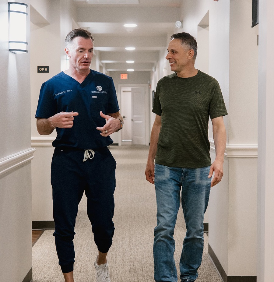 Dr. Oakley of Spring Creek Dentistry walking with happy patient