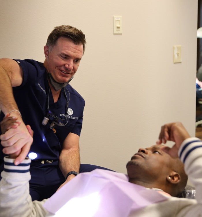 Dr. Oakley shaking hands with a patient