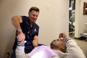 Dr. Oakley shaking hands with patient during dental implant consultation
